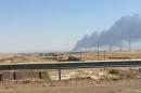 Smoke rises from a oil refinery in Baiji, north of Baghdad