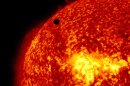This image provided by NASA shows the Solar Dynamic Observatory's ultra-high definition view of Venus, black dot at top center, passing in front of the sun on Tuesday, June 5, 2012. The next transit of Venus won't be for another 105 years. (AP Photo/NASA/Solar Dynamic Observatory)