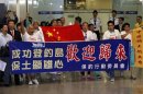 Activists Koo Sze-yiu and Fang Xiao-song, who are part of the group of Chinese activists who went to the disputed Senkuki or Diaoyu islands, hold a Chinese national flag in front of a banner as they arrive at Hong Kong airport