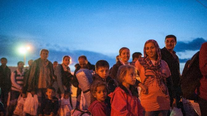 Migrants wait to enter a registration camp after crossing the Greece-Macedonia border near Gevgelija on October 6, 2015