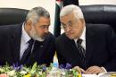 FILE- In this March 18, 2007 file photo, Palestinian Authority President Mahmoud Abbas, right, and Palestinian Prime Minister Ismail Haniyeh of Hamas, left, speak as they head the first cabinet meeting of the new coalition government at Abbas' office in Gaza City. A last-minute dispute has erupted between Hamas and Fatah over the makeup of the Palestinian unity government meant to end the factions' seven-year political split. Palestinian President Mahmoud Abbas, the leader of Fatah, has announced plans to swear in a government of technocrats backed by both factions on Monday, June 2, 2014.(AP Photo, File)