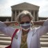In this photo taken, Monday, June 25, 2012, Carol Paris of Leonardtown, Md. demonstrates outside the Supreme Court in Washington. On Thursday the Supreme Court will deliver their ruling on President Barack Obama's health care package. (AP Photo/Evan Vucci)