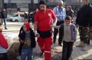 A Syrian Red Crescent worker evacuates children from the besieged Yarmuk Palestinian refugee camp, south of the Syrian capital Damascus on January 19, 2014