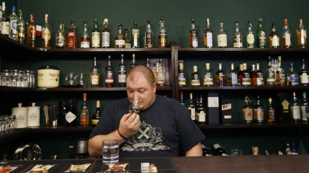 In this Thursday, April 25, 2013 photo Petr Nemy, an whisky expert, tastes the single malt "Hammer Head" whisky in a bar in Prague, Czech Republic. The "Hammer Head" whisky made in communist Czechoslovakia matured in oak barrels for more than twenty years to reach surprisingly good quality before hitting the market. (AP Photo/Petr David Josek)