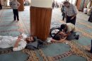 Survivors from what activists say is a gas attack rest inside a mosque in the Duma neighbourhood of Damascus