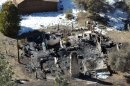 In this aerial photo, law enforcement authorities investigate the charred remains of a cabin Wednesday, Feb. 13, 2013, where quadruple-murder suspect Christopher Dorner is believed to have died after barricading himself inside during a Tuesday stand-off with police in the Angeles Oaks area of Big Bear, Calif. San Bernardino Sheriff's Deputy Jeremiah MacKay was killed and another wounded during the shootout with Dorner. (AP Photo/The Sun, John Valenzuela)