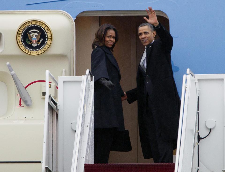 President Barack Obama, accompanied by first lady Michelle Obama, waves prior to boarding Air Force One at Andrews Air Force Base, Md., Monday, Dec. 9, 2013, before traveling to South Africa for a memorial service in honor of Nelson Mandela. ( AP Photo/Jose Luis Magana)
