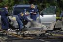Investigators look at the remains of a small plane along Main St, Wednesday, Oct. 12, 2016, in East Hartford, Conn., a day following the plane's crash. The FBI is taking over as lead investigator in the deadly crash of a small plane carrying a flight instructor and a student pilot because of indications that it might have been a criminal act, safety officials said Wednesday. (AP Photo/Jessica Hill)