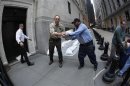 New York Stock Exchange workers place sand bags in front of doors and over electrical vaults at the exchange in New York