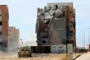 Military vehicle for Libyan forces allied with the U.N.-backed government is stationed in front of ruined buildings at the eastern frontline of fighting with Islamic State militants, in Sirte's neighbourhood 650