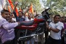 Activists from Shiv Sena, a Hindu hardline group, carry a motor bike as they shout slogans during a protest against the price hike in petrol, in Jammu