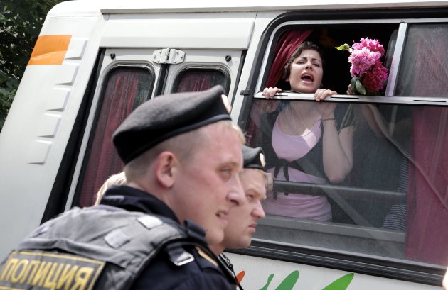 Detained gay rights activists shout from a police bus near the State Duma, Russia's lower parliament chamber, in Moscow, Russia, Tuesday, June 11, 2013. Protesters attempted to rally outside the Russian State Duma before what is expected to be a final vote on the bill banning "propaganda of nontraditional sexual relations." More than two dozen activists were detained in Moscow on Tuesday as they were protesting a bill that stigmatizes the gay community and bans the giving of information about homosexuality to children. (AP Photo/Ivan Sekretarev)