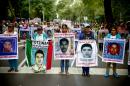 People hold posters of disappeared students during a protest in Mexico city, on September 26, 2015, to commemorate the first anniversary of Ayotzinapa school students disappearance