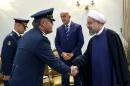 A Lebanese general, left, shakes hands with Iran's President Hassan Rouhani at his office in Tehran, Iran, Sunday, Oct. 19, 2014. In the background is Lebanese Defense Minister Samir Moqbel. (AP Photo/Ebrahim Noroozi)