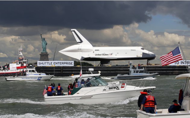 Space Shuttle Enterprise, rides on barge past Statue of Liberty in New York