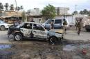 Iraqi security forces inspect the site of car bomb attack in Buhriz