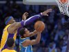 Los Angeles Lakers center Dwight Howard, left, blocks the shot of New Orleans Hornets guard Brian Roberts during the second half of their NBA basketball game, Tuesday, Jan. 29, 2013, in Los Angeles. The Lakers won 111-106. (AP Photo/Mark J. Terrill)
