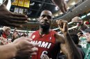El jugador del Heat de Miami, LeBron James, saluda a fanáticos tras vencer a los Celtics de Boston el lunes, 18 de marzo de 2013, en Boston. (AP Photo/Michael Dwyer)