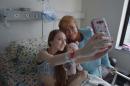 A picture released by the Chilean presidential press office shows President Michele Bachelet posing for a selfie with 14-year-old Valentina Maureira at a hospital in Santiago, on February 28, 2015