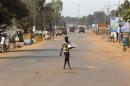 A street vendor crosses a largely empty road in Miskine district, Bangui