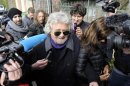 Five Star Movement leader and comedian Beppe Grillo speaks with media before casting his vote at the polling station in Genoa