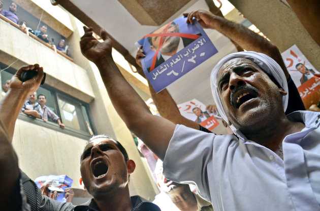 Protesters chant slogans against Egyptian President Mohammed Morsi at a court in Ismailia, 139 Kilometers (86 miles) from Cairo, Egypt, Sunday, June 23, 2013. An Egyptian court on Sunday said Muslim Brotherhood members conspired with Hamas, Hezbollah and local militants to storm a prison in 2011 and free 34 Brotherhood leaders, including Morsi. The poster, top center, in Arabic reads, "the biggest strike of the year, 6/30."(AP Photo/Mostafa Darwish)