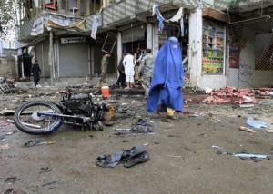 An Afghan woman walks at the site of a suicide attack &hellip;