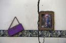 Photo frame and a purse hang on a room wall of a house destroyed by an air strike near Sanaa airport