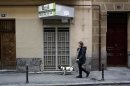 A woman walks past a closed down business in Madrid