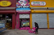 Jessie Rivera, 10, of New York, a young customer of the Lola Star Gift Shop on the Coney Island boardwalk, brings pink sandbags to the door of the shop Sunday, Oct. 28, 2012, in New York. Tens of thousands of people were ordered to evacuate coastal areas Sunday as big cities and small towns across the U.S. Northeast braced for the onslaught of a superstorm threatening some 60 million people along the most heavily populated corridor in the nation.. (AP Photo/Craig Ruttle)