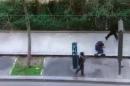 FILE - In this image made from amateur video recorded on Wednesday, Jan. 7, 2015, file photo by Jordi Mir, masked gunman walk past a police officer moments after shooting him at blank range outside the offices of French satirical newspaper Charlie Hebdo in Paris. Though it is impossible to gauge in any tangible way the effect the deadly attack on a Paris newspaper will have on recruitment by extremist groups - and there is no evidence so far that it is mobilizing large numbers of would-be jihadis - experts believe the perceived professionalism of the brothers' assault and their subsequent showdown with police could rally more supporters to militant ranks. (AP Photo/Jordi Mir, File) NO SALES