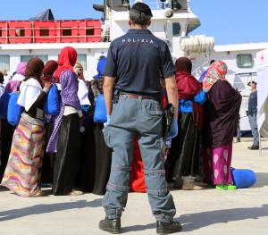 A police officer watches migrants disembarking from&nbsp;&hellip;