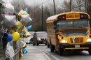 FILE - In this Dec. 18, 2012 file photo, a school bus rolls toward a memorial in Newtown, Conn., for victims of the Sandy Hook Elementary School shooting. Nearly three weeks after the shooting rampage, classes are starting Thursday, Jan. 3, 2013 for the Sandy Hook students at a repurposed school in the neighboring town of Monroe, where the students' desks have been taken along with backpacks and other belongings that were left behind in the chaos following the shooting on Dec. 14. (AP Photo/Charles Krupa, File)