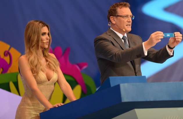 O secretário-geral da Fifa, Jerôme Valcke (D), ao lado de Fernanda Lima (E), mostra o papel com o nome da Espanha, atual campeã mundial