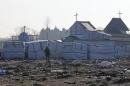 FILE PHOTO - A migrant walks past the church in the dismantled aera of the camp for migrants called the "Jungle", in Calais