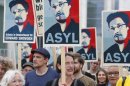 Demonstrators hold banner during protest rally in support of Snowden in Berlin
