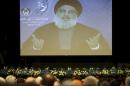 Hezbollah leader Sheikh Hassan Nasrallah speaks via video to his supporters in the southern suburb of Beirut, Lebanon, Friday Jan. 9, 2015. The leader of the Lebanese Hezbollah group said Islamic extremists have insulted the prophet of Islam with their terror more than those who published drawings mocking him. (AP Photo/Hussein Malla)