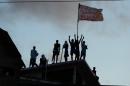 Prisioners atop the roof of the compound celebrate the transfer of their leaders after a negotiation with the police at the Alcacuz Penitentiary, near Natal, Rio Grande do Norte, on January 16, 2017