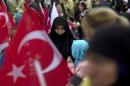 An AK Party supporter is seen through Turkish national flags during an election rally in Diyarbakir