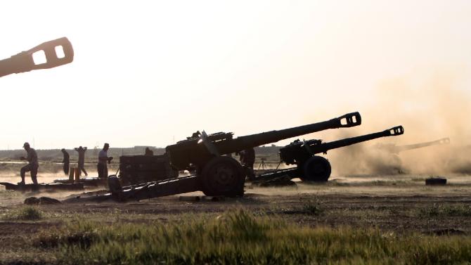 Pro-Iraqi government forces fire Howitzer Cannons towards positions of the Islamic State group on the outskirts of the northern city of Tikrit during a military operation to retake control of the city on March 10, 2015