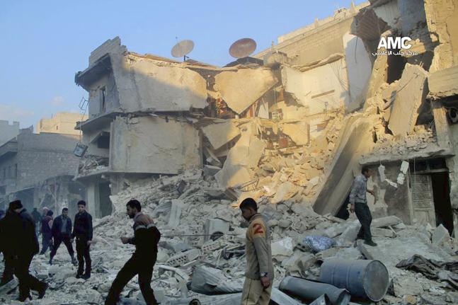 In this Sunday, Dec. 15, 2013 citizen journalism image provided by Aleppo Media Center, AMC, which has been authenticated based on its contents and other AP reporting, Syrians inspect the rubble of damaged buildings following a Syrian government airstrike in Aleppo, Syria. The Britain based Syrian Observatory for Human Rights said Monday that dozens of children were among scores killed in airstrikes on several opposition areas a day earlier. (AP Photo/Aleppo Media Center AMC)