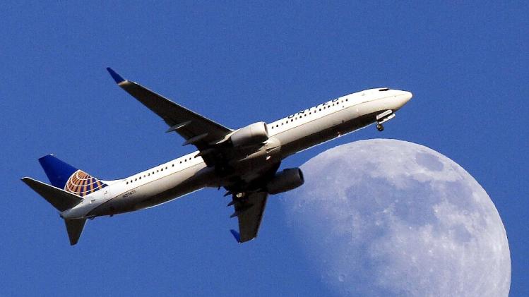 FILE - In this July 17, 2013 file photo, a United Airlines jet plane landing at Los Angeles International Airport, in Whittler City Calif., passes in front of a Waxing Gibbous moon. United Airlines reports quarterly earnings on Thursday, April 24, 2014. ( AP Photo/Nick Ut, File)