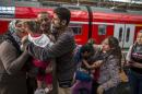 Ihab, a Syrian migrant from Deir al-Zor, cries as he and his family are welcomed by his relatives upon their arrival at the railway station in Lubeck