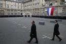 President Francois Hollande and Prime Minister Manuel Valls (R) arrive on January 13, 2015 for a ceremony to decorate the three police officers killed in the recent Islamist attacks with the Legion d'honneur, at the Invalides Hotel in Paris