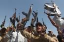 Iraqi Shiite men raise their weapons as they gather in Jdaideh in the Diyala province on June 14, 2014