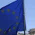 A E.U. flag flutters in front of the monument of Parthenon on Acropolis hill in Athens