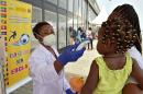 A medical worker checks the temperature of a young girl an airport in Bata, Equatorial Guinea, on January 15, 2015