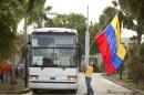 Guillermo Beltran waves his country's flag as Venezuelans from South Florida prepare for their bus trip to Washington, Thursday, May 8, 2014, in Doral, Fla. They are rallying to ask the Congress and President Barack Obama to impose economic sanctions and travel restrictions to the Venezuelan government officials because of presumed human right violations in the South American country. Organizers said they expect Venezuelans from 19 states will meet in Washington on Friday to demonstrate in front of the White House, Congress and the Organization of American States. (AP Photo/J Pat Carter)