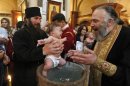 Georgian babies are baptized at the Holy Trinity Cathedral in Tbilisi, Georgia, on Sunday, May 6, 2012. Many of the parents of the 400 babies baptized on Sunday said Georgian Orthodox Church Patriarch Ilia II was instrumental in their decision to have a third or fourth child. Patriarch Ilia II promised to become the godfather of all babies born into Orthodox Christian families who already have two or more children and since 2008 has gained nearly 11,000 godchildren. (AP Photo/ Shakh Aivazov)