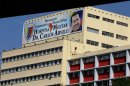A banner bearing a photo of Venezuela's President Hugo Chavez is displayed on a building of the Carlos Arvelo Military Hospital in Caracas, where the ailing leader is expected to continue his treatment, in Caracas, Venezuela, Monday, Feb. 18, 2013. Chavez returned to Venezuela early Monday after more than two months of medical treatment in Cuba following cancer surgery, and was being treated at the Caracas' military hospital, his government said. (AP Photo/Fernando Llano)